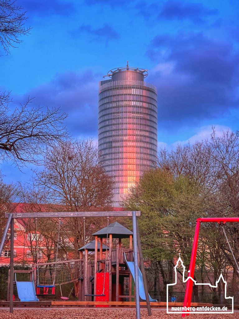 Business Tower Nürnberg während des Sonnenuntergangs hinter einem Kinderspielplatz am Wöhrder See - Foto: Ardan Füßmann